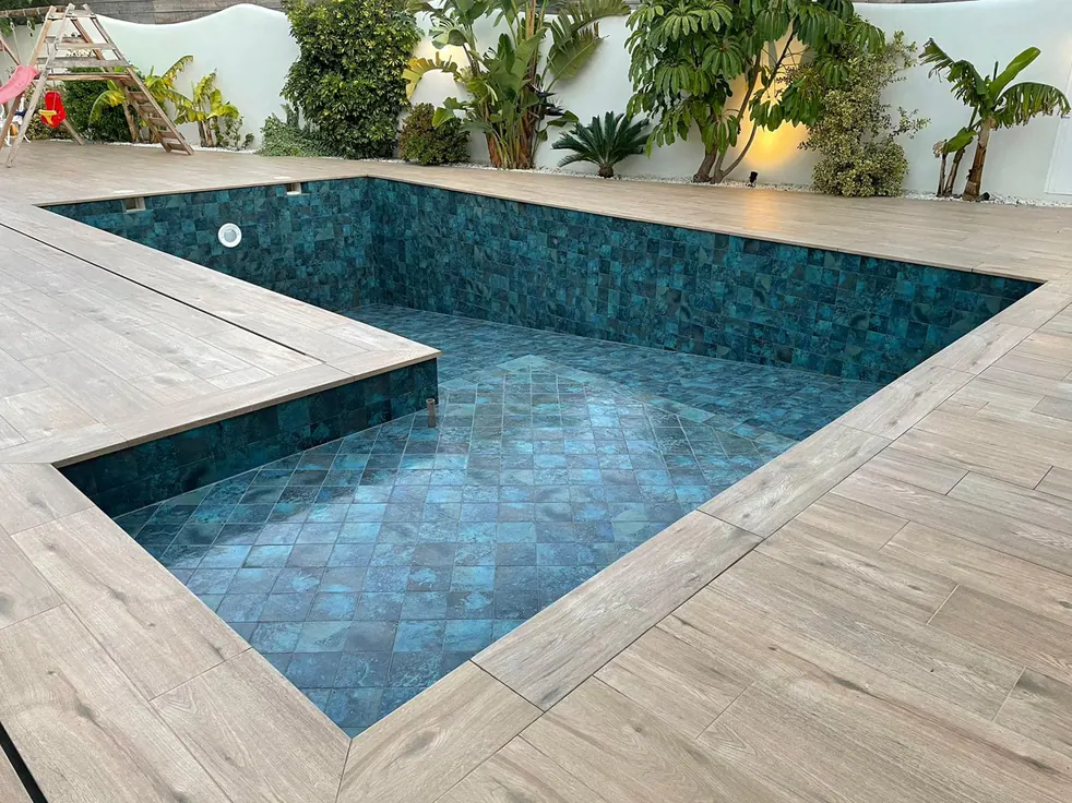 Vaso de obra vacío con gresite verde azulado, poyete interior y coronación de porcelánico imitación madera, imagen de recurso sobre piscinas de obra en Tenerife